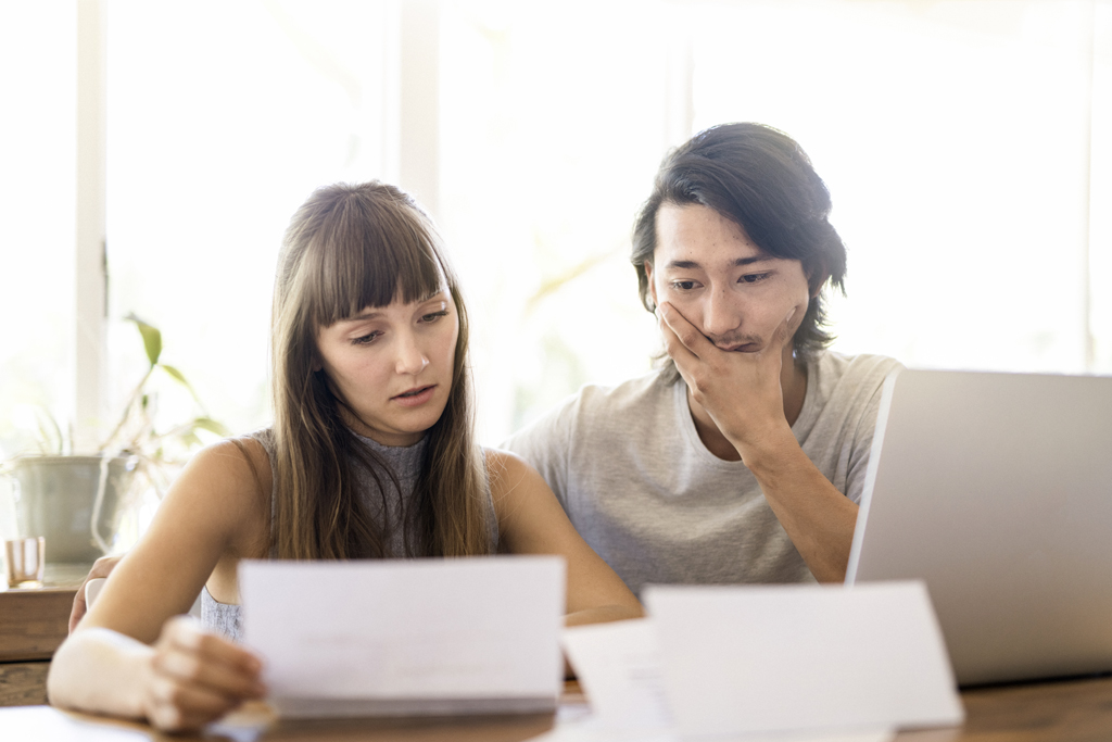 a couple looking at papers and a computer